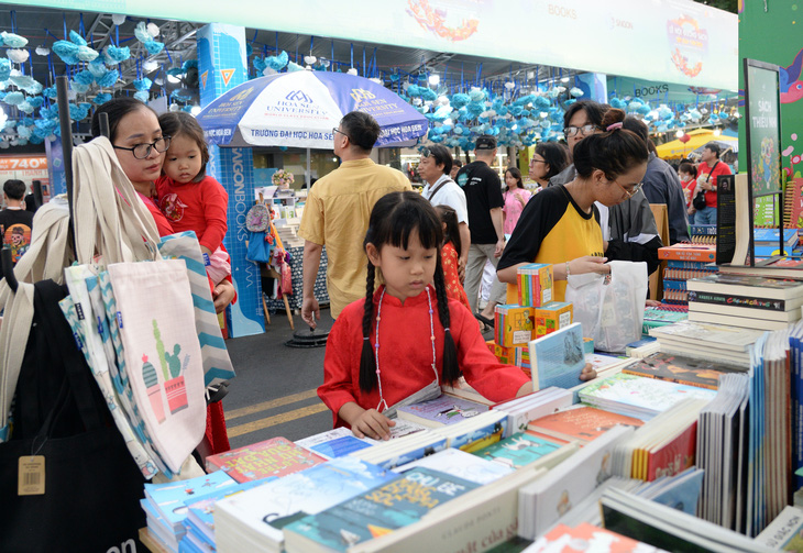 Người dân TP lựa chọn sách tại lễ hội Đường sách Tết Giáp Thìn trong ngày đầu năm mới