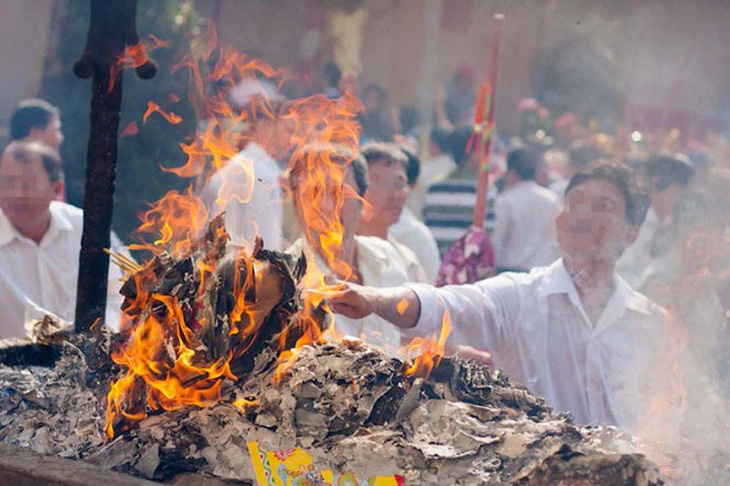 Người dân đốt vàng mã tại một chùa ở Bình Dương - Ảnh: TIẾN THÀNH