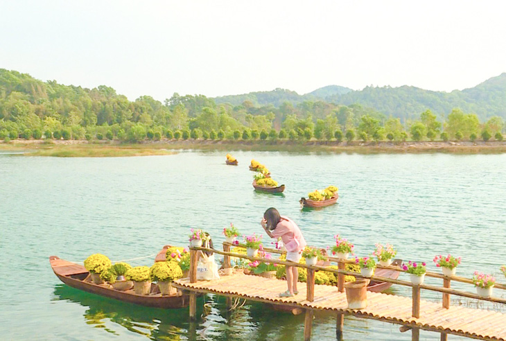 Khách du lịch chụp ảnh Tết bên tiểu cảnh xuồng hoa ở hồ Đá Dựng (TP Hà Tiên, Kiên Giang) - Ảnh: KIM TRANG