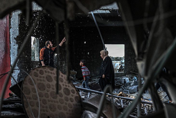 Người dân sơ tán khỏi một tòa nhà bị hư hại nặng nề do bom của Israel tại Rafah, phía nam Dải Gaza, ngày 11-2 - Ảnh: AFP