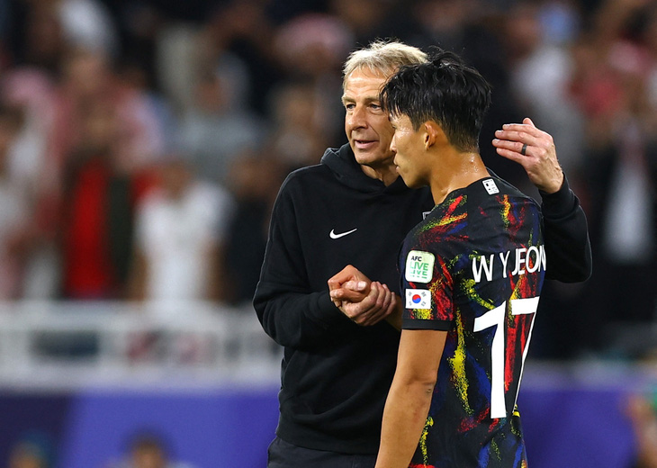 HLV Klinsmann an ủi cầu thủ Hàn Quốc sau trận thua Jordan - Ảnh: Reuters