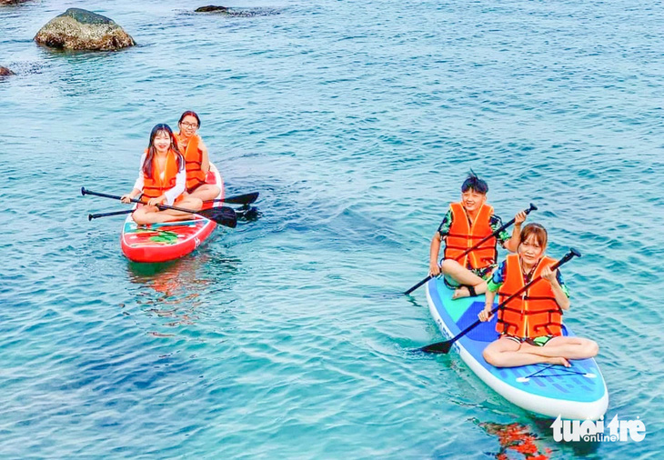 Du khách trẻ thích trải nghiệm chèo sup trên biển ngắm hoàng hôn ở Hòn Sơn, Nam Du (huyện Kiên Hải) - Ảnh: C.CÔNG