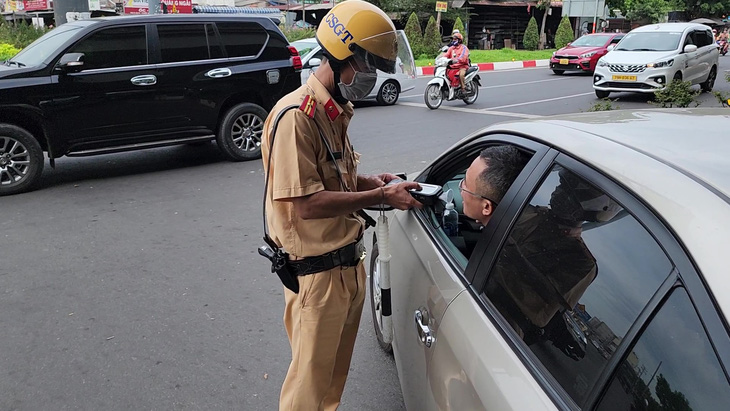 Cảnh sát giao thông TP.HCM kiểm tra nồng độ cồn người đi đường - Ảnh: MINH HÒA