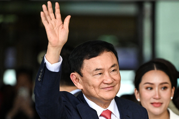 Cựu thủ tướng Thái Lan Thaksin Shinawatra chào những người ủng hộ bên cạnh con gái ông, Paetongtarn Shinawatra (phải) sau khi đáp xuống sân bay Don Mueang ở Bangkok vào ngày 22-8-2023 - Ảnh: AFP