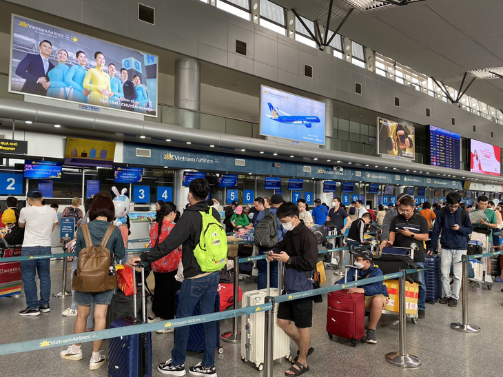 Hành khách xếp hàng chờ vào làm check-in chuyến bay từ Đà Nẵng đến TP.HCM trưa 14-2 - Ảnh: MỸ CHI