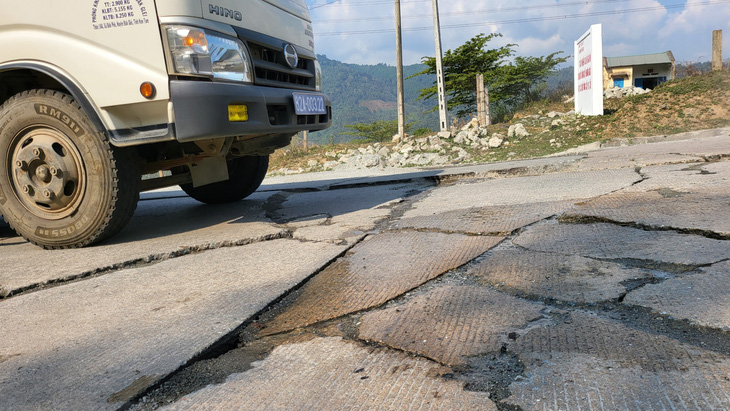 Xe tải chạy qua một điểm nứt vỡ mặt đường trên tuyến đường Hồ Chí Minh qua đèo Lò Xo - Ảnh: H.P. 