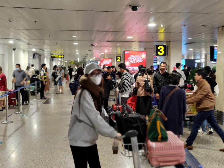 Hành khách chờ lấy hành lý tại khu vực băng chuyền ga quốc nội Tân Sơn Nhất ngày 14-2 - Ảnh: A.BÌNH