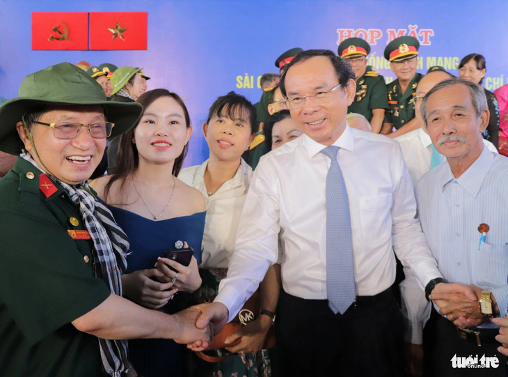 Bí thư Thành ủy TP.HCM Nguyễn Văn Nên (giữa) bắt tay thăm hỏi các cán bộ lão thành cách mạng - Ảnh: CẨM NƯƠNG