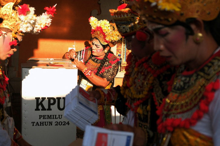 Trang phục sặc sỡ của nhân viên bỏ phiếu tại một điểm bầu cử trên đảo Bali - Ảnh: REUTERS