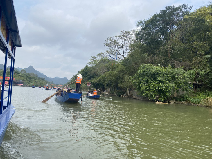 Đến gần trưa 14-2 dòng thuyền, đò trên suối Yến chở khách đi lễ chùa Hương vẫn nhộn nhịp, đông đúc - Ảnh: BÙI TRIỂU