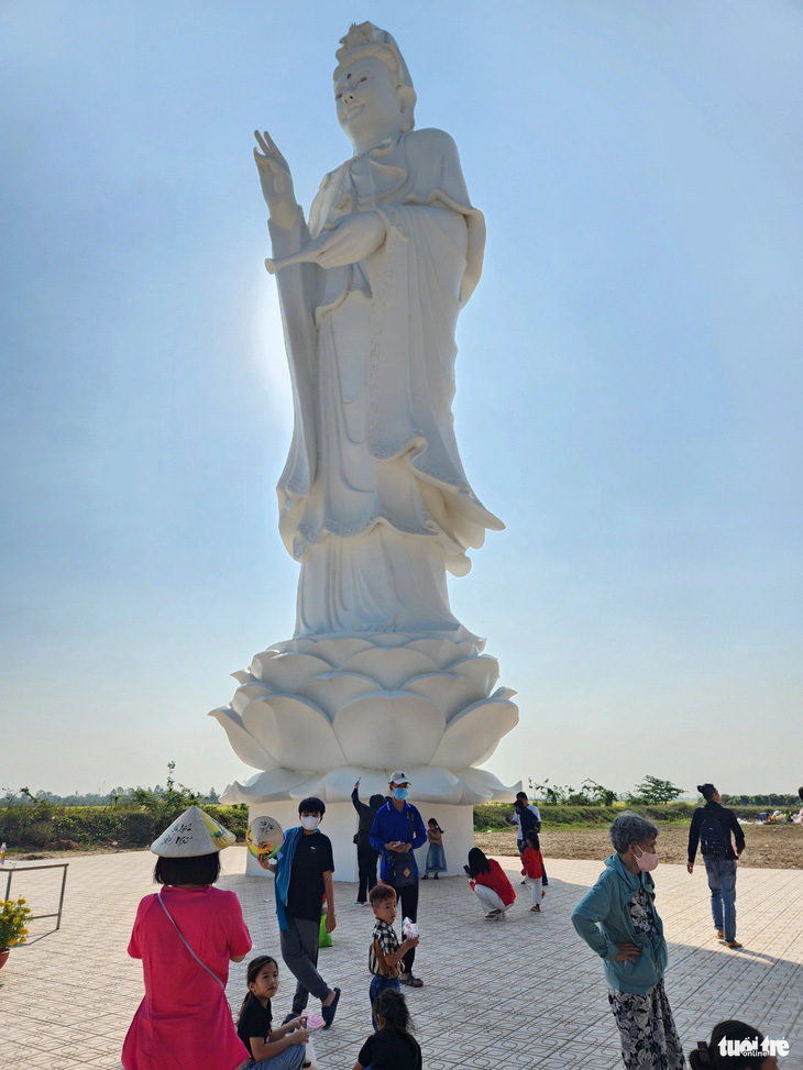Du khách về tham quan, cúng viếng luôn muốn chụp ảnh với tượng Quan Thế Âm Bồ Tát cao 21m trước cửa chùa Núi Nổi - Ảnh: BỬU ĐẤU