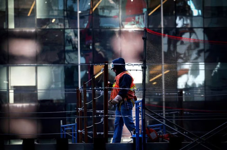 Một công nhân xây dựng làm việc trên nóc tòa nhà One Times Square đang được cải tạo thành không gian bất động sản thương mại mới ở Manhattan, New York, Mỹ ngày 7-2-2024 - Ảnh: REUTERS