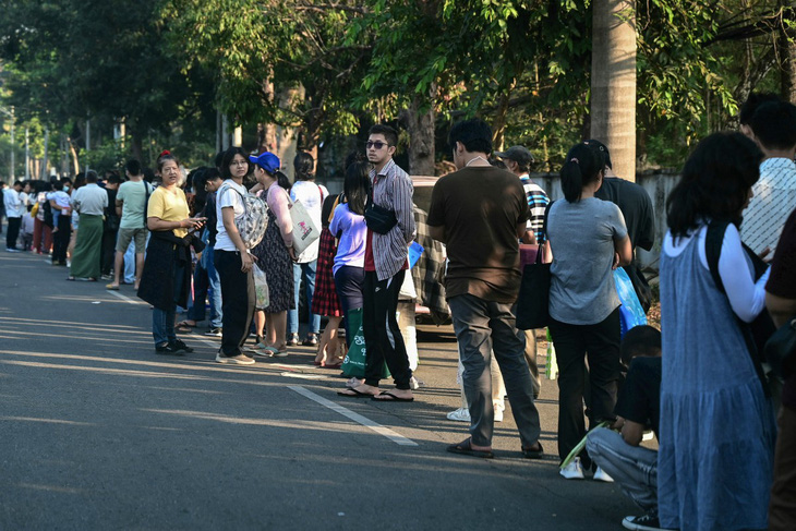 Khoảng 1.000 người xếp hàng đợi trước cửa Đại sứ quán Thái Lan ở thủ đô Yangon từ sáng sớm 16-2 - Ảnh: AFP