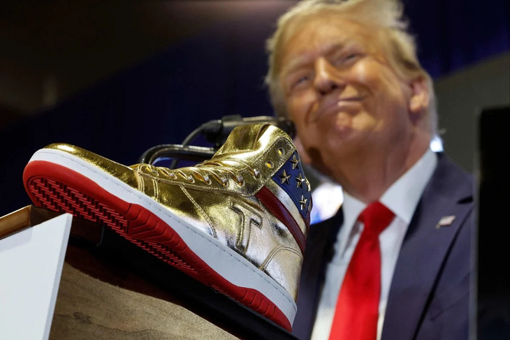 Ông Donald Trump chụp ảnh cùng mẫu giày &quot;Không bao giờ đầu hàng&quot; vừa được ra mắt - Ảnh: AFP