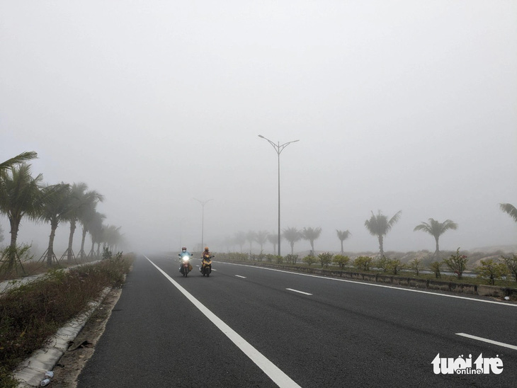 Người lái xe máy cũng giảm tốc độ, mở đèn pha khi đi qua đoạn đường dày đặc sương mù 