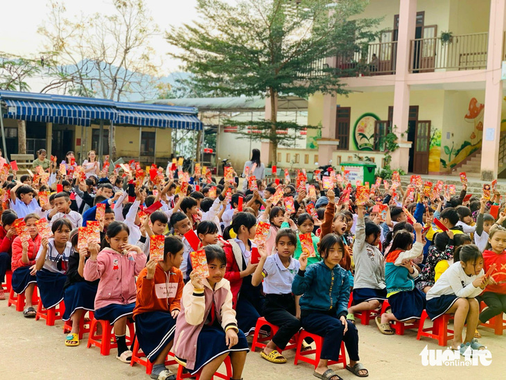 Học sinh một trường tiểu học miền núi Nam Trà My, Quảng Nam khoe bao lì xì đầu năm mới - Ảnh: CLB 