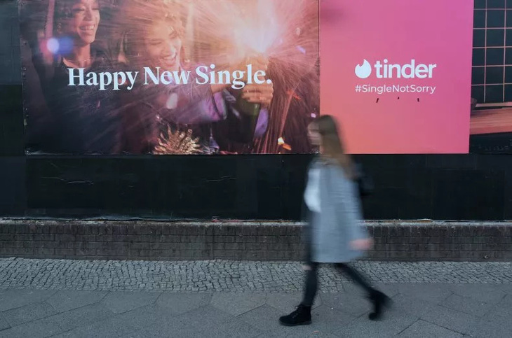 Một cô gái trẻ đi ngang qua biển quảng cáo của ứng dụng hẹn hò Tinder vào ngày 18-2-2024 tại Đức - Ảnh: Getty