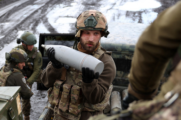 Một người lính Ukraine ôm quả đạn pháo tại tiền tuyến Bakhmut, vùng Donetsk - Ảnh: AFP