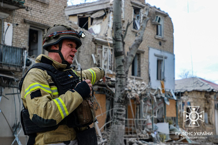 Nhân viên cứu hộ bên ngoài một tòa nhà bị hư hại sau vụ không kích của Nga ở trung tâm thành phố Kherson, ảnh đăng ngày 2-2 - Ảnh: AFP