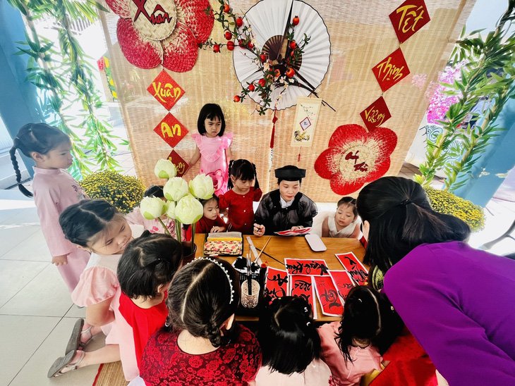 Trẻ mầm non của Trường mầm non Thành Phố (quận 3, TP.HCM) thích thú với khu vực viết chữ thư pháp tại Lễ hội Xuân Giáp Thìn 2024 ở trường - Ảnh: MỸ DUNG