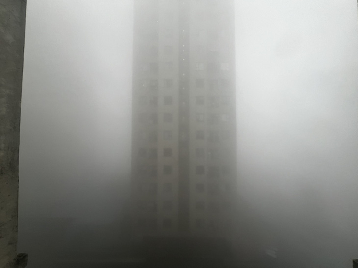 Tòa nhà cao tầng chìm trong sương mù lúc 7h45 sáng 2-2 - Ảnh: NAM TRẦN