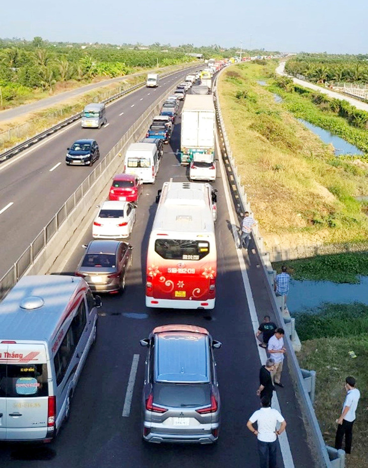 Kẹt xe kéo dài trên cao tốc Trung Lương - Mỹ Thuận, nhiều tài xế  chờ quá lâu đã xuống xe hóng mát - Ảnh: KHẮC CƯỜNG