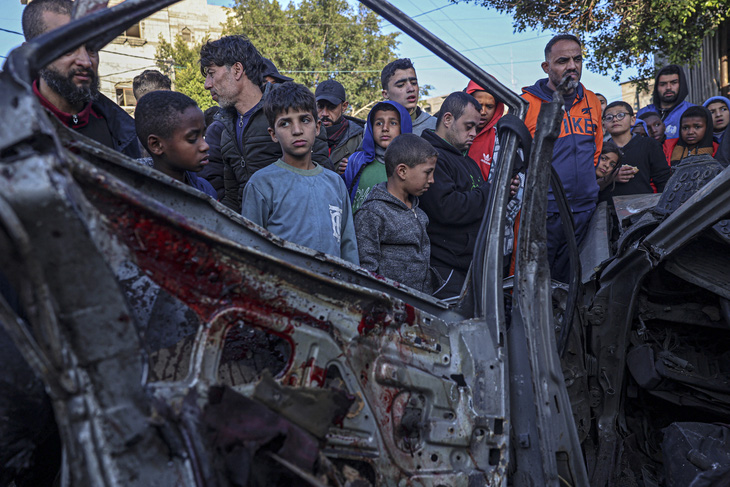 Người xem tập trung xung quanh một chiếc ô tô bị phá hủy trong cuộc đột kích của Israel ở Rafah, phía nam Dải Gaza vào ngày 20-2 - Ảnh: AFP