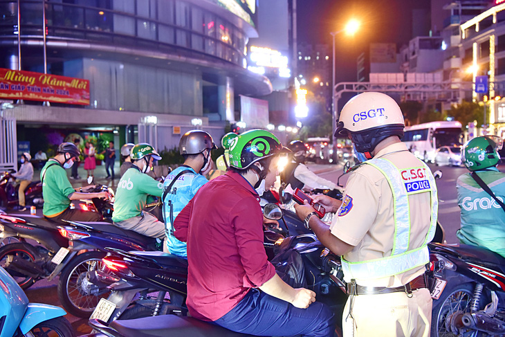 Cảnh sát giao thông đo nồng độ cồn người điều khiển xe gắn máy tại quận Phú Nhuận, TP.HCM - Ảnh: T.T.D.