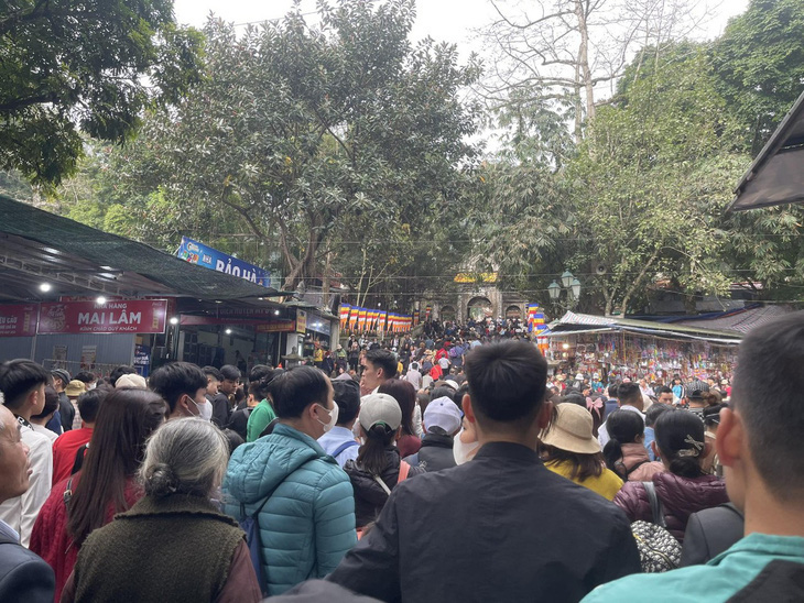 Đường vào chùa Thiên Trù luôn đông người vào sáng 14-2. Số lượng người đi chơi hội vẫn đông, nhưng tình trạng hỗn loạn mà báo chí phản ánh trong những năm trước không còn nữa - Ảnh: BÙI TRIỀU