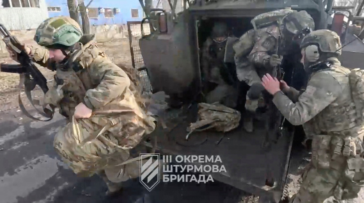 Binh sĩ Ukraine rời khỏi xe quân sự tại một địa điểm ở Avdiivka. Ảnh chụp lại từ video clip công bố ngày 17-2 - Ảnh: REUTERS