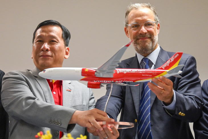 Phó giám đốc điều hành kinh doanh máy bay thương mại Benoit de Saint-Exupery của Airbus và CEO Đinh Việt Phương (trái) của Vietjet trong lễ ký kết tại Triển lãm hàng không Singapore ngày 22-2-2024 - Ảnh: AFP