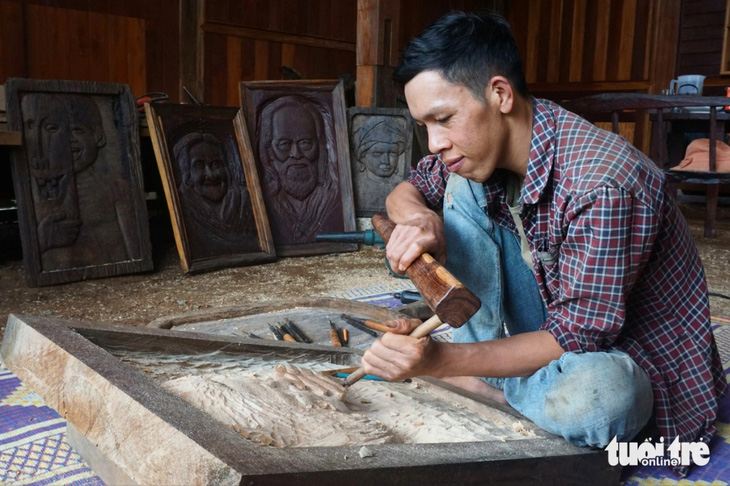 Anh Tăng Minh Thuận biến những khúc gỗ bỏ đi thành tranh khắc gỗ có giá trị - Ảnh: TRẦN HƯỚNG