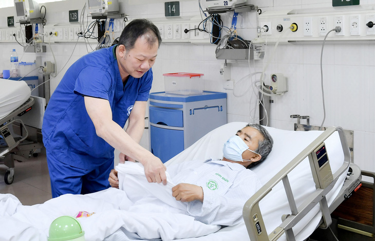 Bác sĩ Dương Đức Hùng, giám đốc Bệnh viện Hữu nghị Việt Đức, một cựu bác sĩ nội trú, đang thăm khám cho người bệnh - Ảnh: PHƯƠNG HỒNG