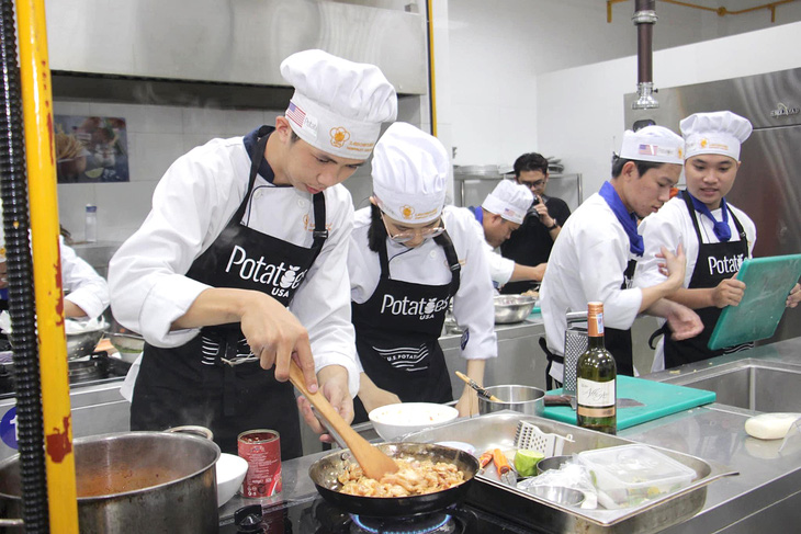 Hoàng Anh (bìa trái) trong một cuộc thi nấu ăn tại trường - Ảnh: NVCC
