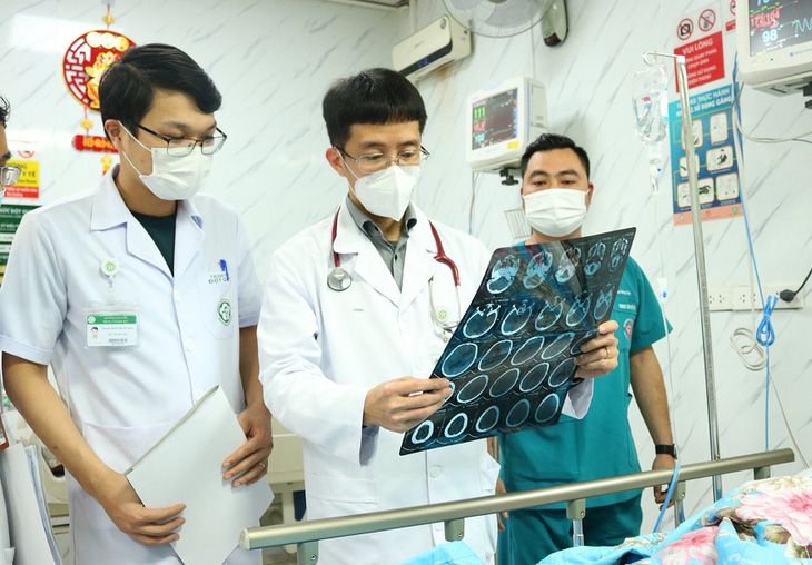 PGS.TS Mai Duy Tôn (giữa) thăm khám cho bệnh nhân sau đột quỵ não - Ảnh: BVCC