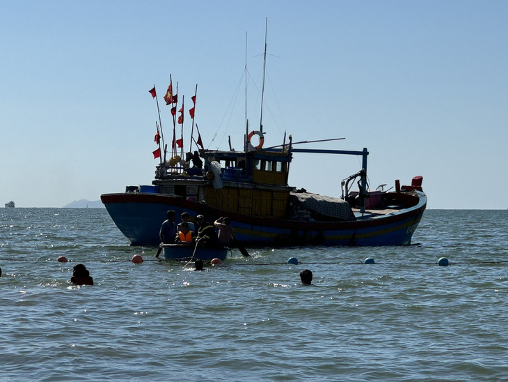 Lực lượng cảnh sát phòng cháy chữa cháy - cứu nạn cứu hộ Công an tỉnh Bình Định phối hợp cùng người dân đưa cá voi trở về biển - Ảnh: N.H.T.
