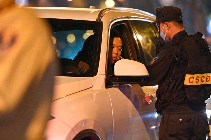 Cảnh sát kiểm tra nồng độ cồn với tài xế - Ảnh: HỒNG QUANG