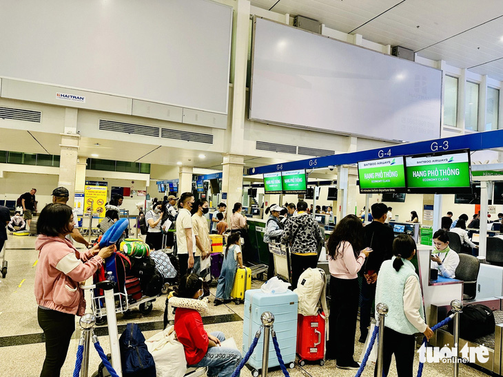 Hành khách làm thủ tục check-in ở Tân Sơn Nhất dịp Tết 2024 - Ảnh: CÔNG TRUNG