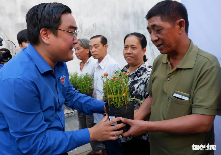 Phó bí thư thường trực Thành Đoàn TP.HCM Ngô Minh Hải trao hoa và cờ Tổ quốc cho bà con ở chung cư Bình Phú (quận 6) tại lễ ra quân Tháng thanh niên 2024