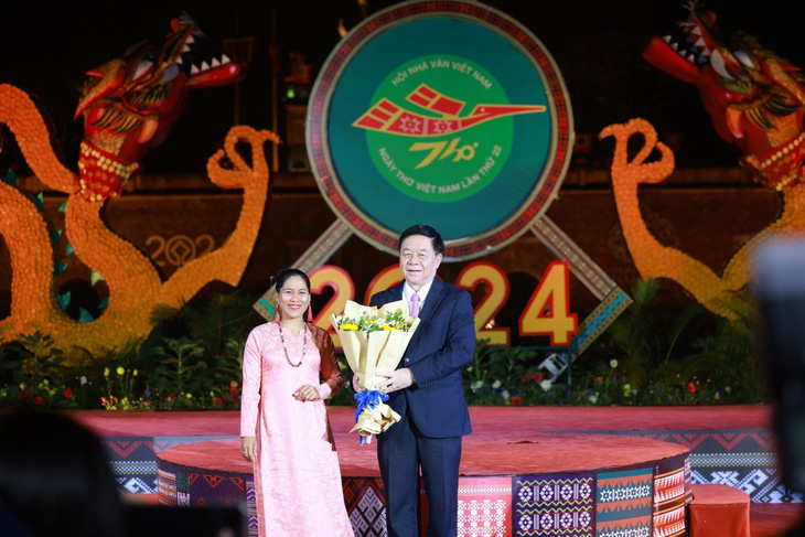 Trưởng Ban Tuyên giáo Trung ương Nguyễn Trọng Nghĩa tặng hoa cho nhà thơ dân tộc Chăm Kiều Maily tại đêm thơ Bản hòa ca đất nước - Ảnh: HUYỀN CHI