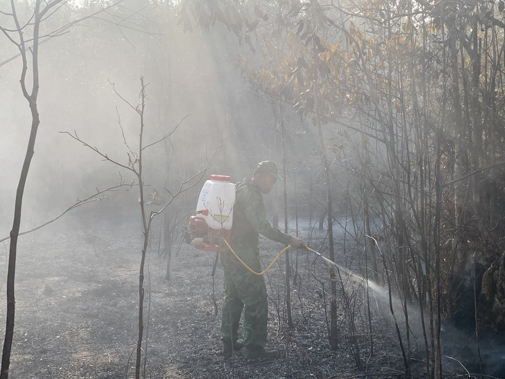 Để hạn chế cháy rừng, cán bộ chiến sĩ Bộ đội biên phòng Kiên Giang sử dụng nước tưới để không cho lửa bén cháy lại - Ảnh: Bộ đội biên phòng cung cấp