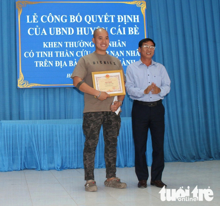 Phó chủ tịch UBND huyện Cái Bè Phan Thanh Sơn trao giấy khen cho anh Phan Quốc Huy - Ảnh: H.T.