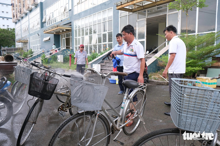 Cán bộ nhân viên Trung tâm quản lý ký túc xá Đại học Quốc gia TP.HCM rửa lại những chiếc xe đạp cũ để gửi trao đến trẻ em khó khăn - Ảnh: NGỌC PHƯỢNG