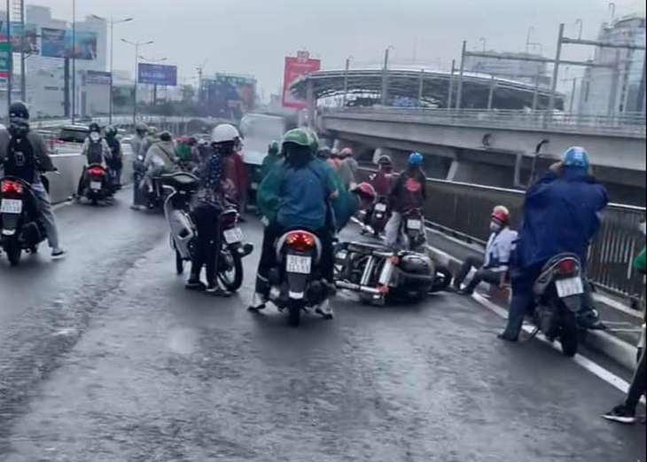 Nhiều người đi đường té ngã trên cầu Sài Gòn sau cơn mưa giải nhiệt - Ảnh: TÚ NGUYỄN 