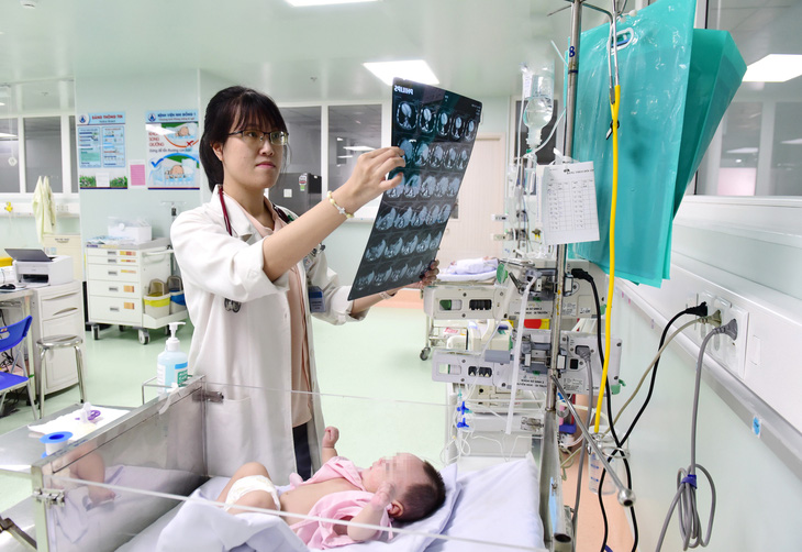 Bác sĩ Chu Thị Hồng Phượng - 28 tuổi, trẻ nhất trong khoa sơ sinh 2 Bệnh viện Nhi đồng 1 - thăm khám cho bệnh nhi - Ảnh: D.PHAN