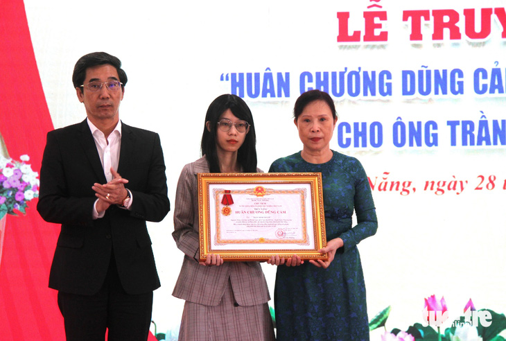 Ông Trần Chí Cường - phó chủ tịch UBND TP Đà Nẵng - trao tặng Huân chương Dũng cảm cho thân nhân ông Trần Minh Thành - Ảnh: LP