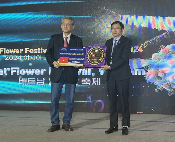 Ông Đặng Quang Tú (bên phải) - chủ tịch UBND TP Đà Lạt - nhận chứng nhận từ IFEA ASIA - Ảnh: NGUYỄN ĐỨC DŨNG