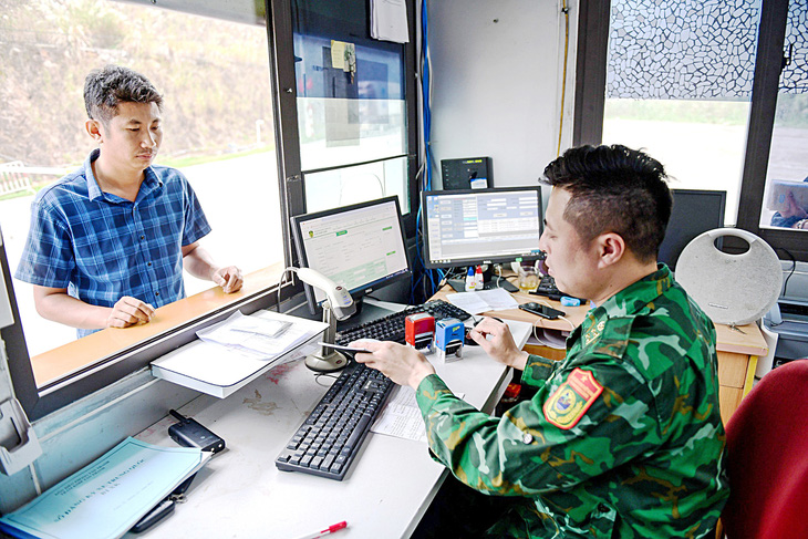 Cán bộ biên phòng kiểm tra kỹ thông tin lái xe, hàng hóa và tiến độ thực hiện thủ tục trên nền tảng cửa khẩu số trước khi thông quan sang Trung Quốc, mất 1-2 phút - Ảnh: NAM TRẦN