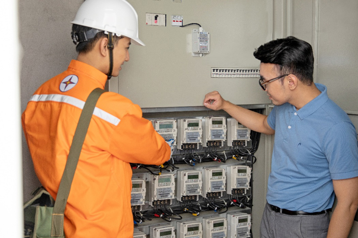 Nhân viên điện lực Hà Nội kiểm tra công tơ với khách hàng - Ảnh: EVN Hà Nội