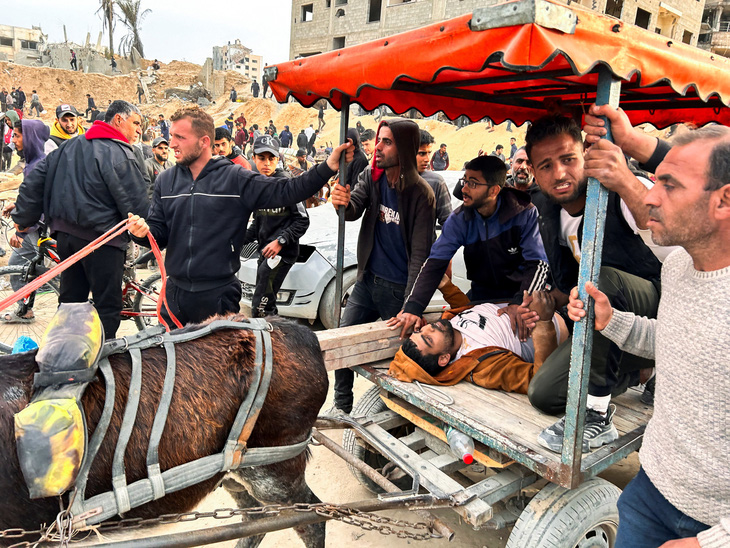 Một người Palestine bị thương nằm trên xe giữa dòng người chờ xe tải chở hàng cứu trợ tại thành phố Gaza, Dải Gaza ngày 26-2 - Ảnh tư liệu: REUTERS